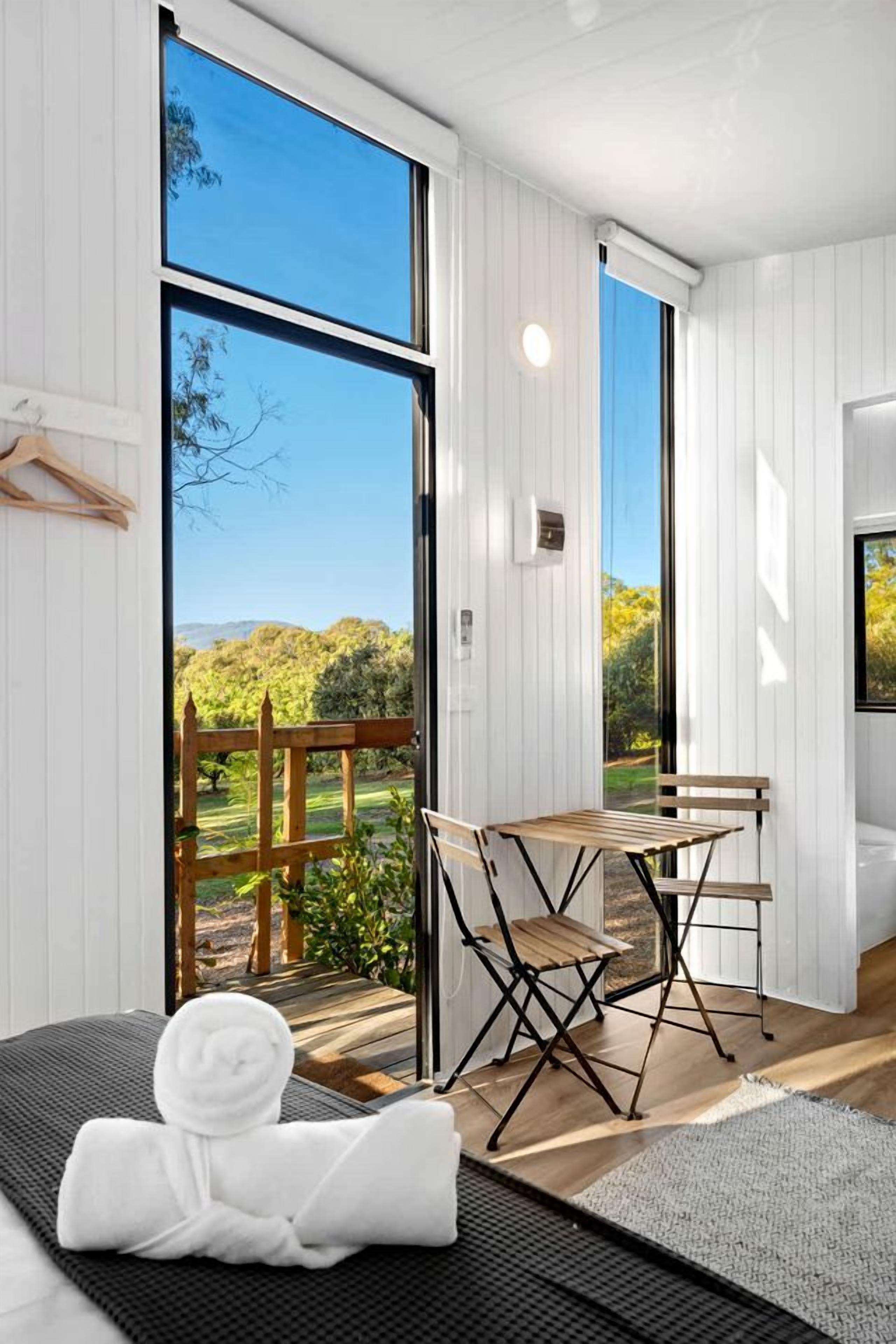 A room with a large window, a wooden table, and a chair.