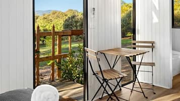 A room with a large window, a wooden table, and a chair.