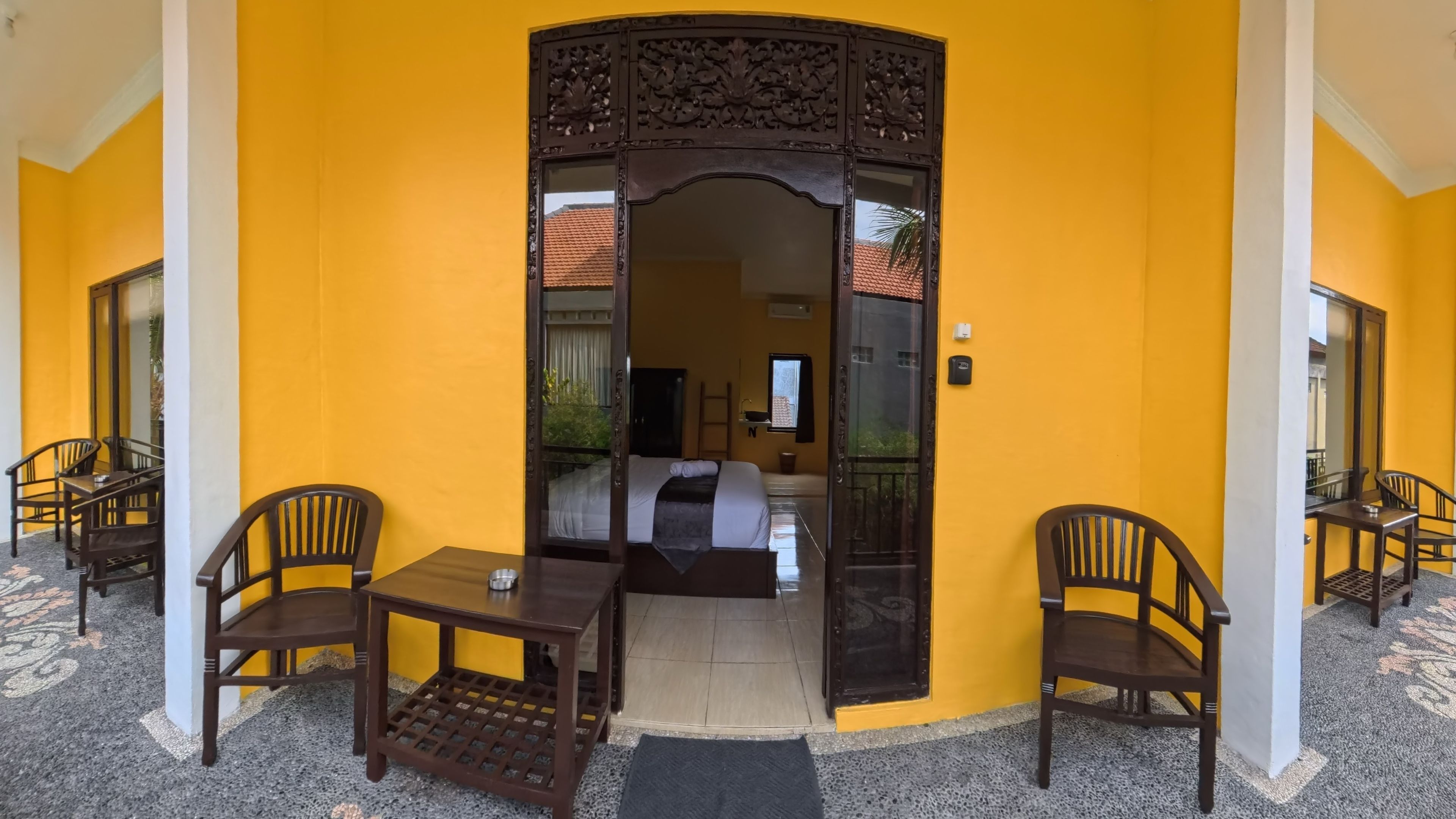 A room with a bed, a table, and two chairs.