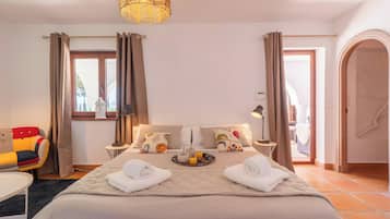 Een hotelkamer met een bed, nachtkastjes, een stoel en uitzicht.
