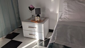 Ein Schlafzimmer mit einem Bett, einem Nachttisch mit Lampe und einem dekorativen Gegenstand darauf.