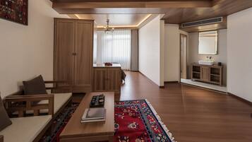 A modern living room with a wooden floor, a sofa, a coffee table, and a rug.
