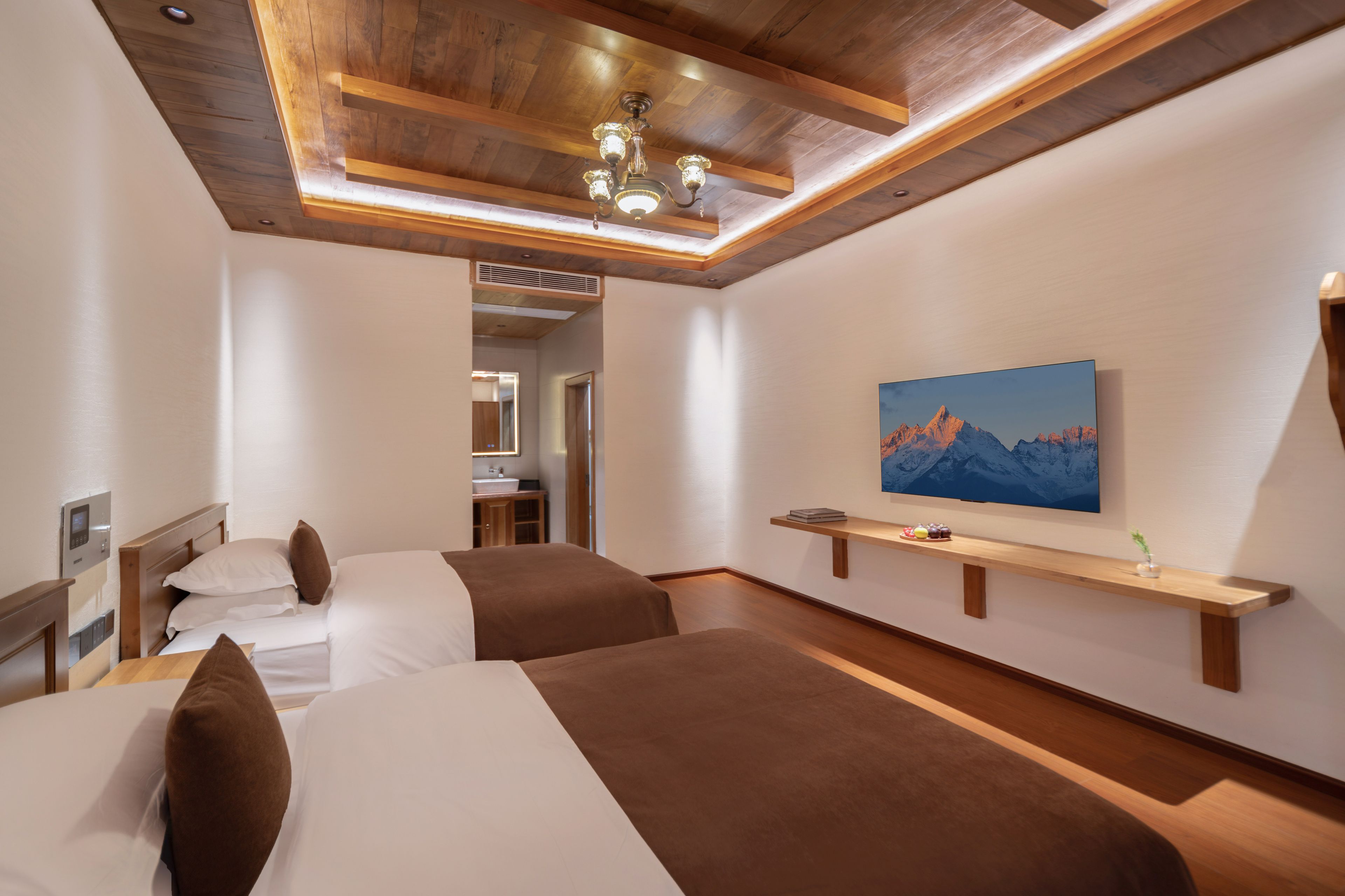 A hotel room with two beds, a mounted TV, and a wooden ceiling.