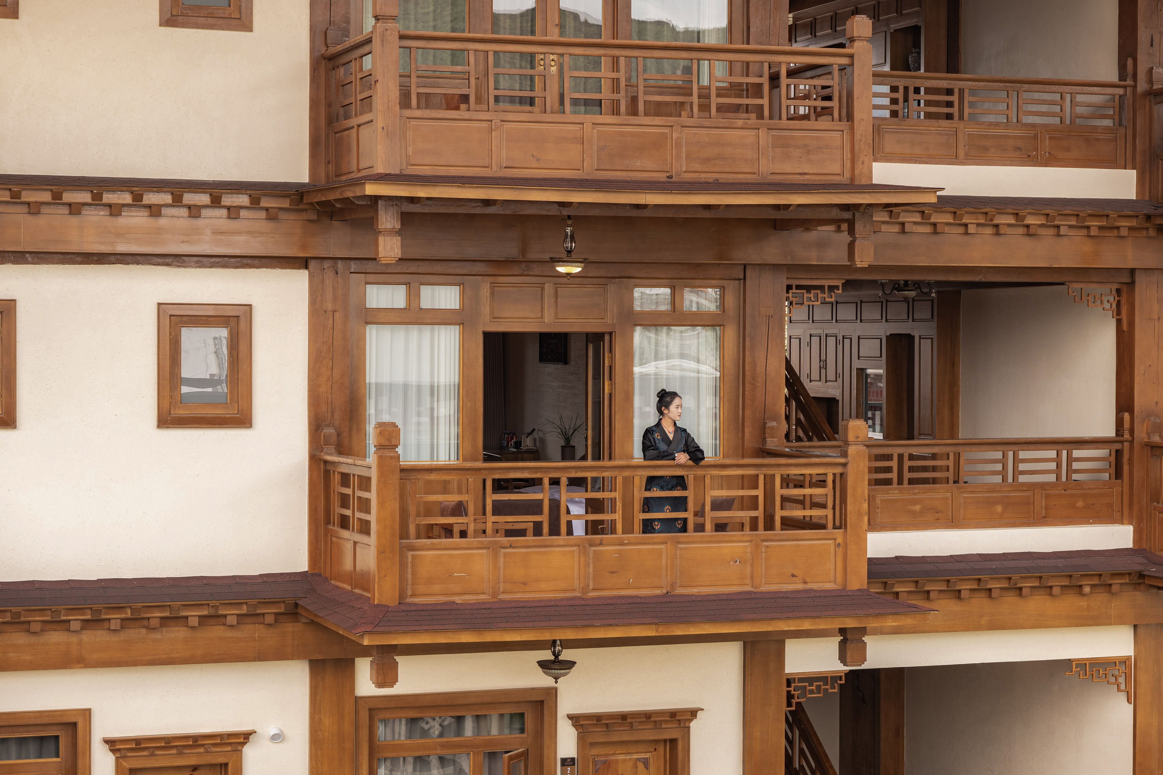 Um edifício de vários andares com varandas de madeira e detalhes arquitetônicos tradicionais.