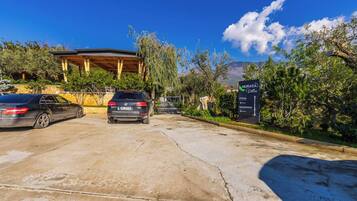 A parking area with a sign for 'Muraga Villas' indicating the entrance and reception.