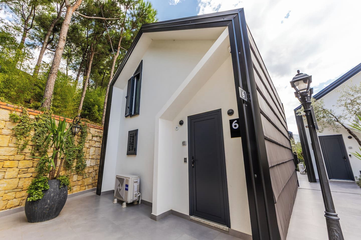 Un edificio moderno con una puerta negra y un cartel con el número 6.
