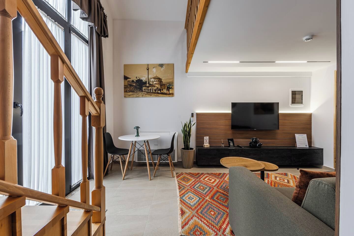 Una sala de estar moderna con televisión, asientos y un comedor.