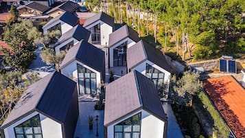 A modern residential area with multiple houses featuring geometric roofs and large windows.