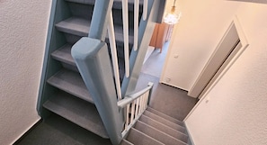 Eine Treppe mit Geländer und einer Lampe darüber.