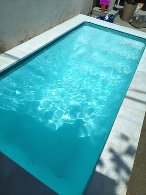 A rectangular swimming pool with clear blue water, surrounded by a concrete deck. - Alma Zen House - Comfort and beach (180m) Air Conditioning/Heated Pool (Guaratuba)
