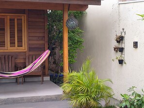 A wooden door, a hammock, and potted plants in a courtyard. - Alma Zen House - Comfort and beach (180m) Air Conditioning/Heated Pool (Guaratuba)