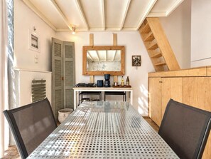 Un coin repas comprenant une table, des chaises, une machine à café et un buffet en bois.