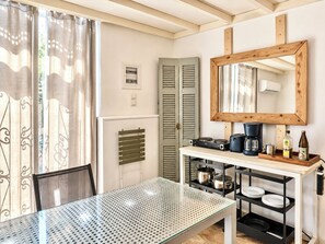 Eine Küchenzeile mit Kaffeemaschine, einer Flasche und einem Spiegel an der Wand.