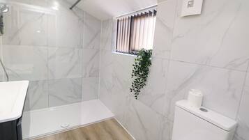 A bathroom with a shower, toilet, and sink.