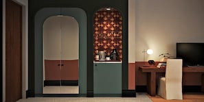 A modern room with a large arched doorway, a television, and a desk with a lamp.