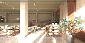 A spacious dining area with multiple tables and chairs, a large potted plant, and a checkered floor pattern.
