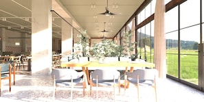 A spacious dining area with a long table, chairs, and potted plants.