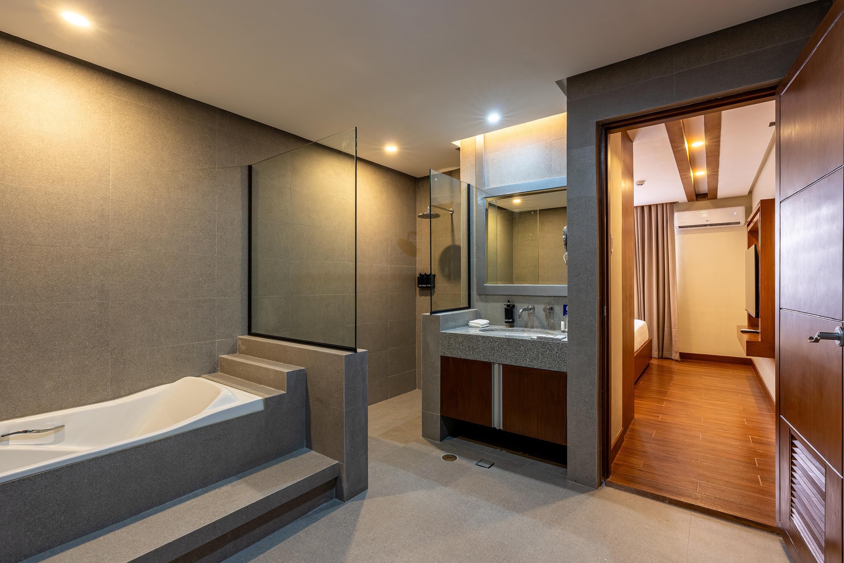 Un baño moderno con bañera, lavamanos y zona de ducha.