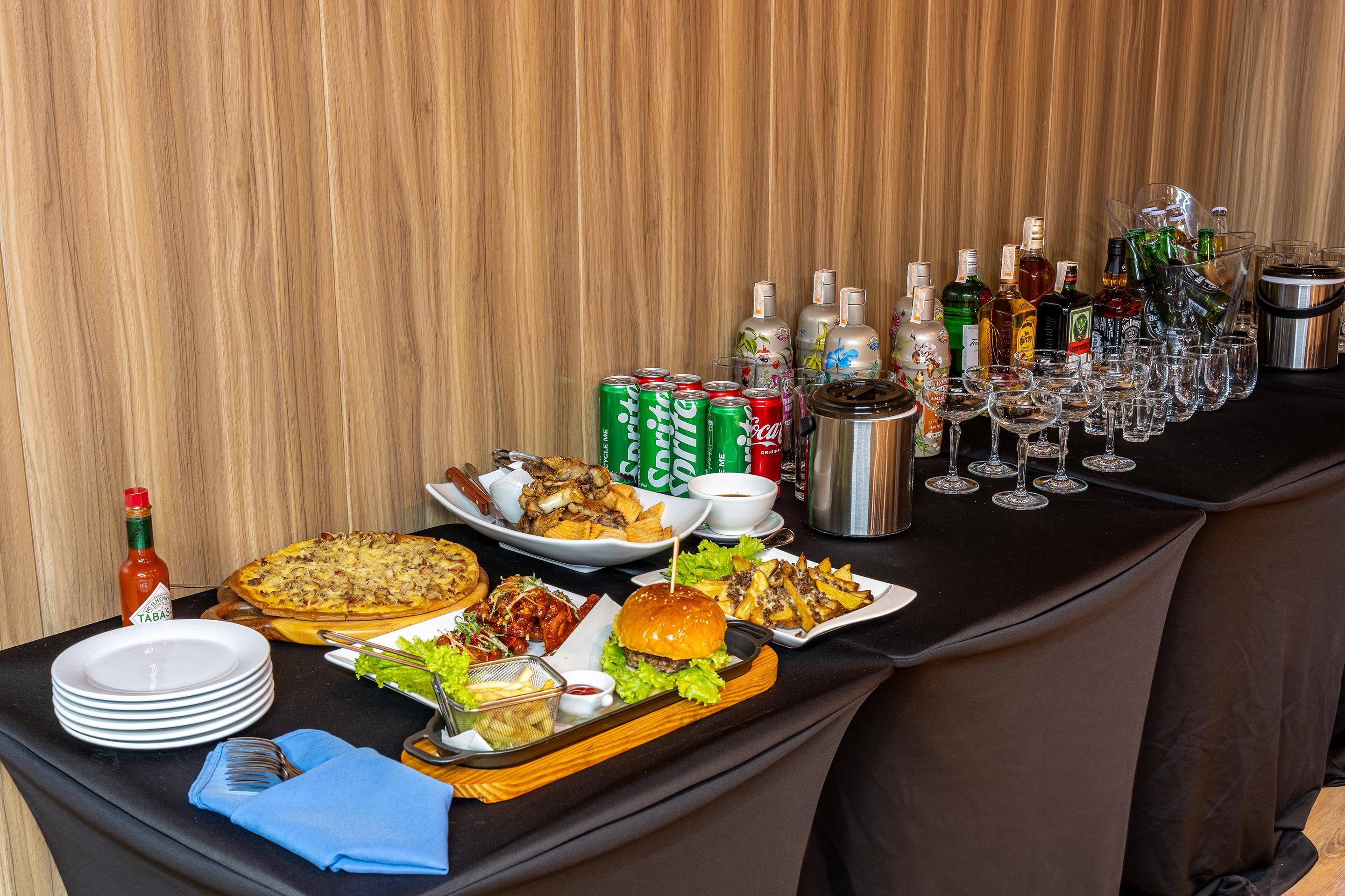 A buffet table with various food items, drinks, and condiments.