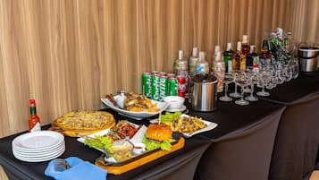 A buffet table with various food items, drinks, and condiments.