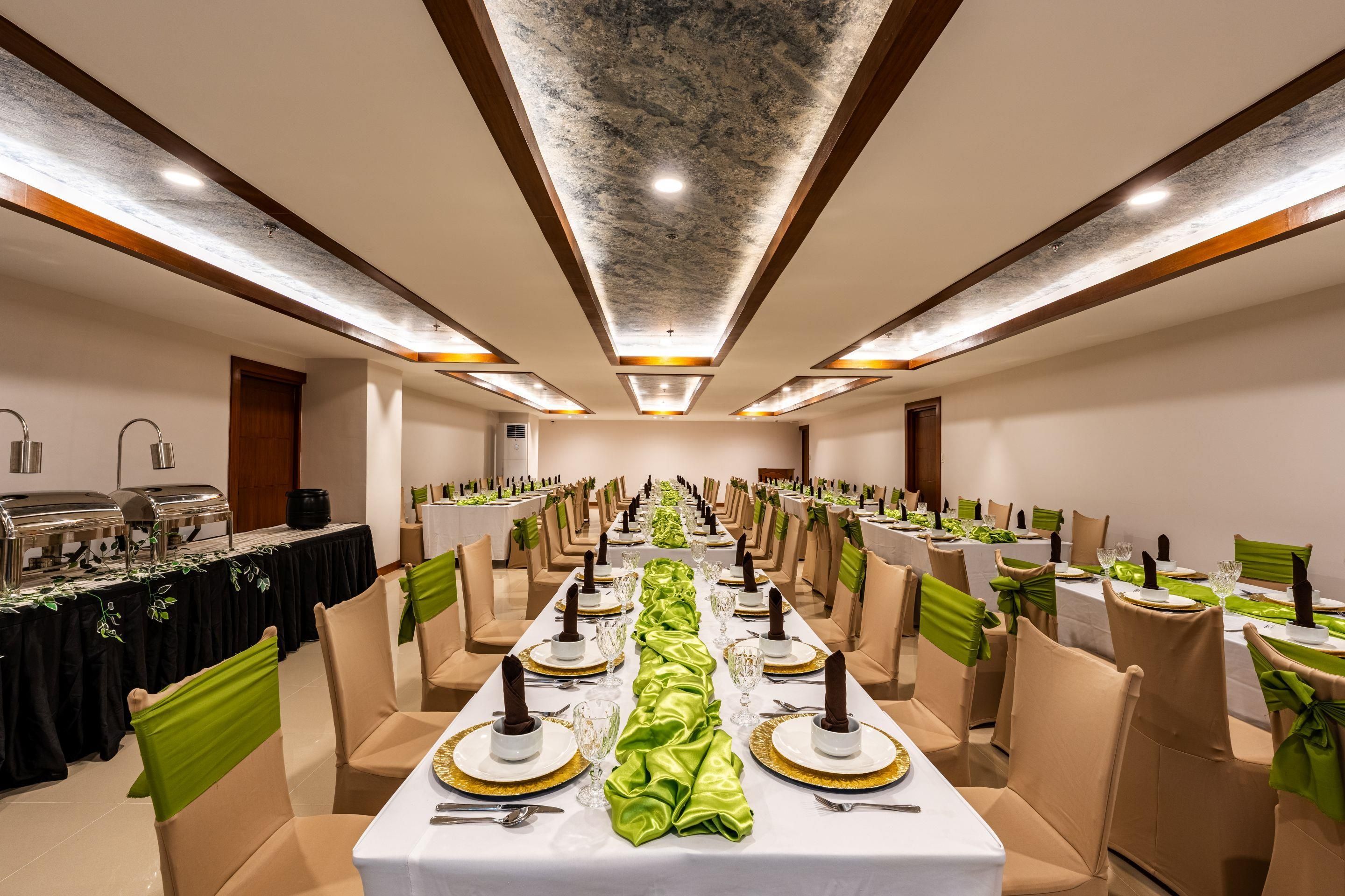 A banquet hall with long tables, chairs, and a ceiling with recessed lighting.