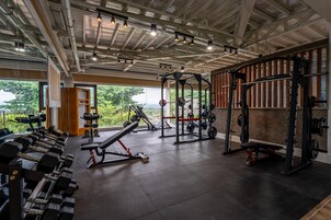 A gym with various exercise equipment, including dumbbells, a bench, and weight machines.
