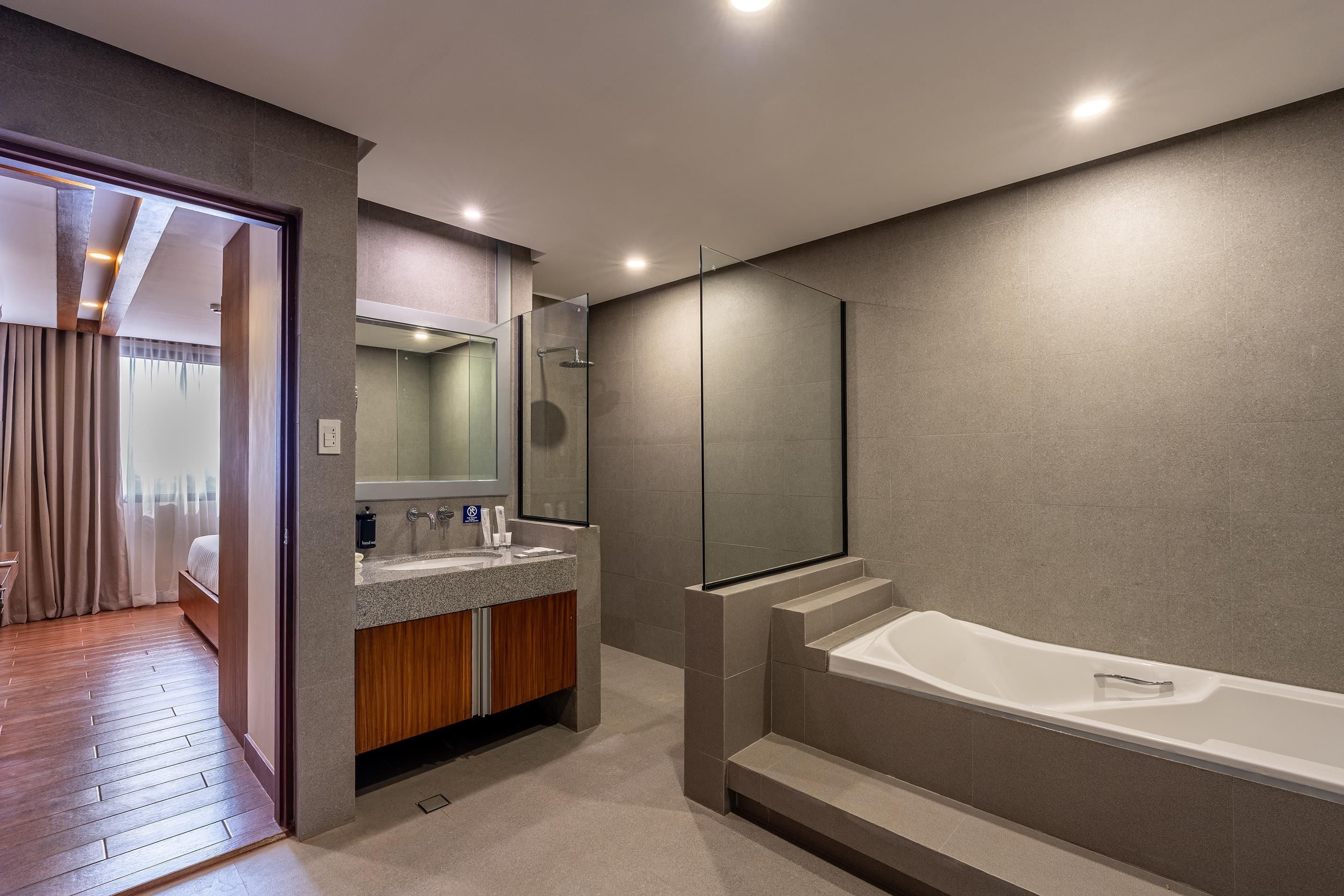 Un baño moderno con una bañera amplia, un tocador doble y un box de ducha de cristal.