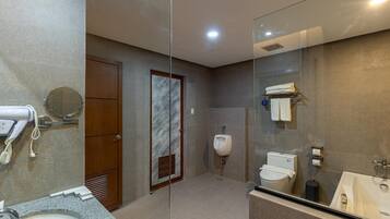A modern bathroom with a granite countertop, a sink, a toilet, a bidet, and a glass shower enclosure.