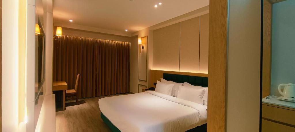 A hotel room with a bed, a desk, and a chair.