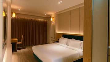A hotel room with a bed, a desk, and a chair.