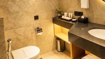 A modern bathroom with a marble floor, a white sink, a mirror, and a towel rack.