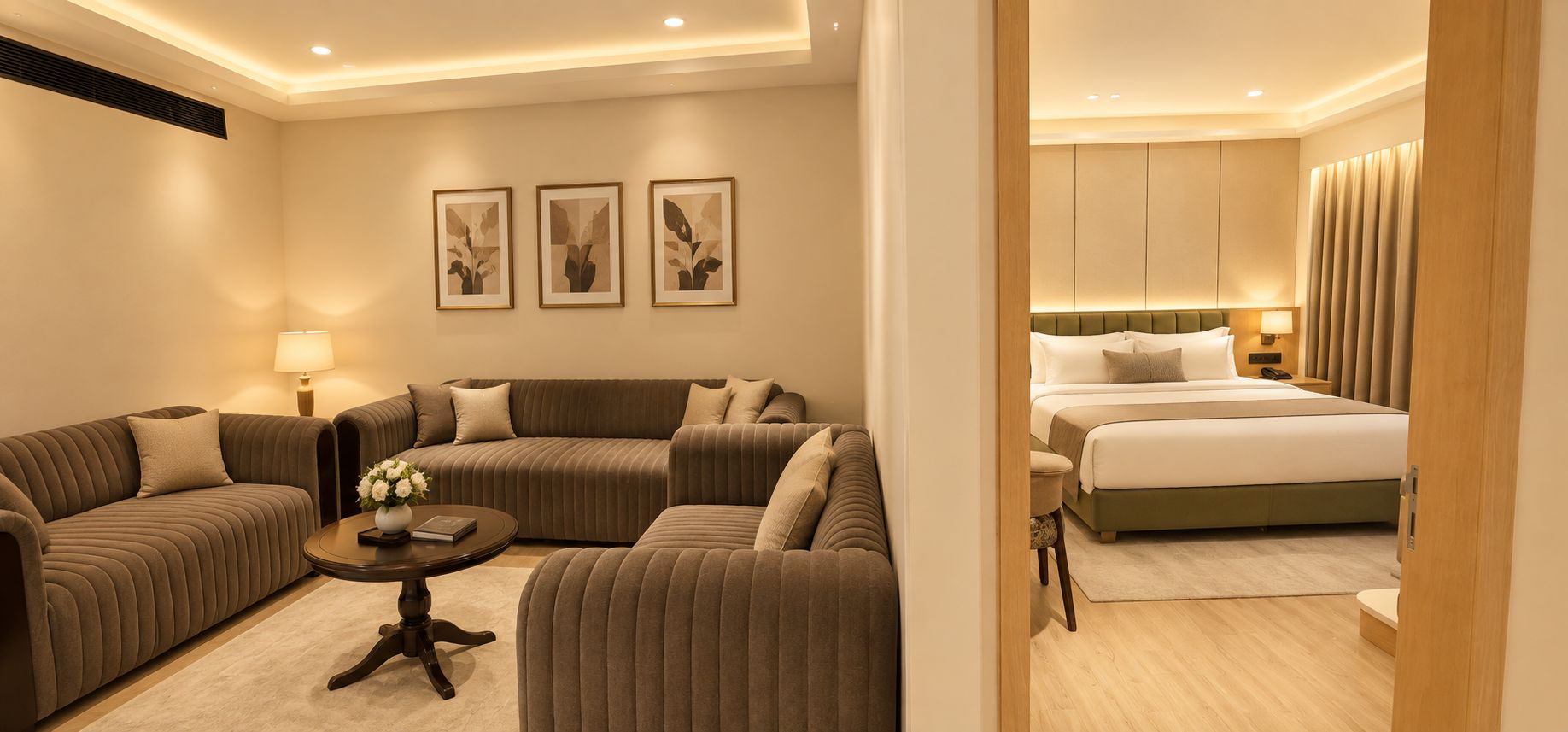 Una habitación de hotel con un conjunto de sofás, una mesita redonda, una cama y una mesita de noche.