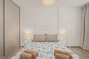 Een slaapkamer met een bed, twee bedlampen, een hoofdeinde en een raam.
