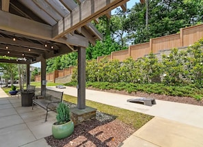 Un espacio al aire libre con patio, una pérgola, mobiliario y un jardín ajardinado.