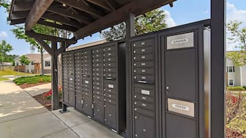 A row of mailboxes with labels for years 1817 to 1824, a trash bin, and a covered walkway.
