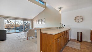 A modern kitchen with a large window, wooden cabinets, and a built-in sink. - Lakefront• Stunning Views • Free Boat Slip (Osage Beach)