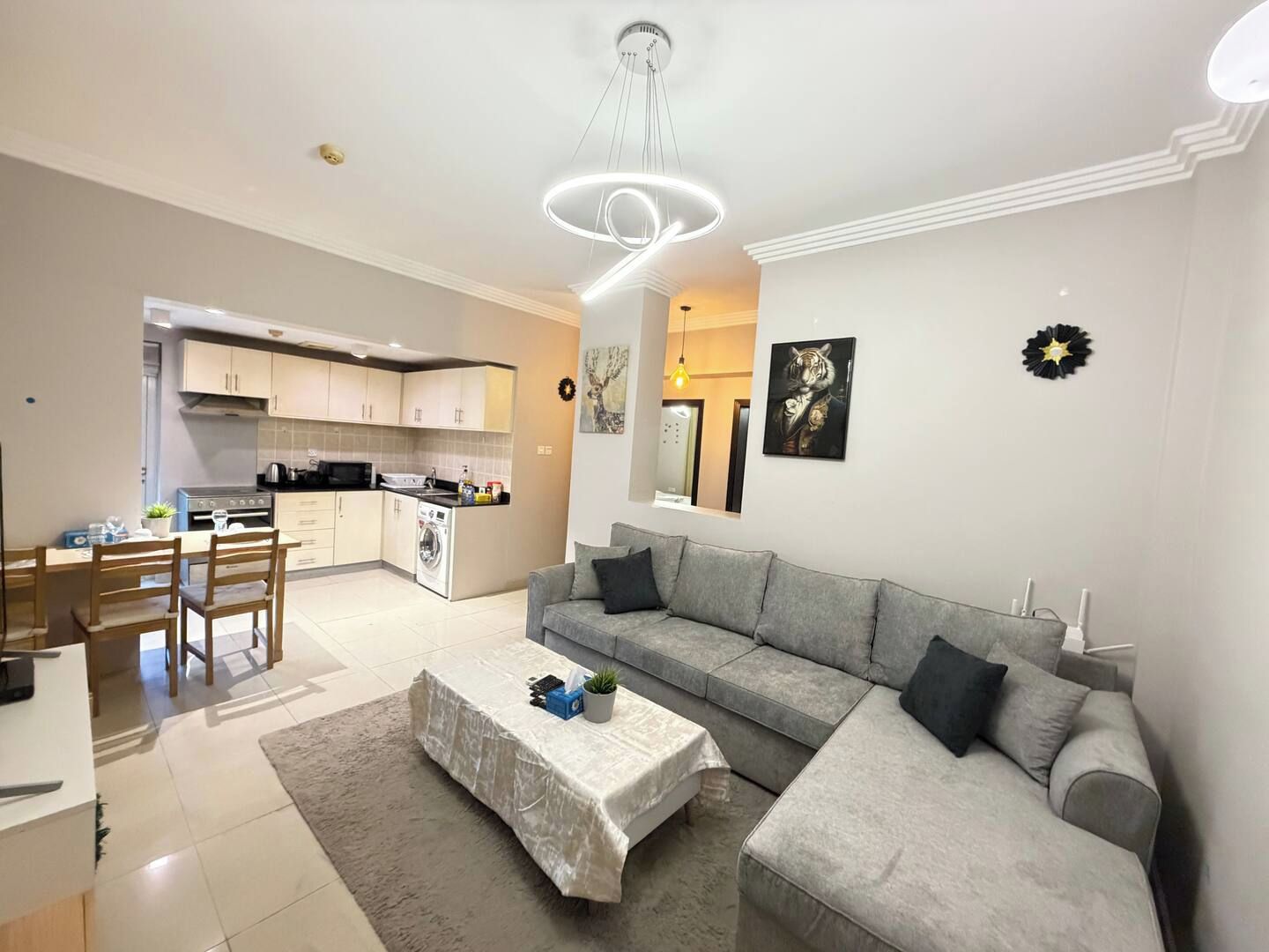 Una sala moderna con un sofá gris, una mesa de centro y un comedor con una mesa y sillas.