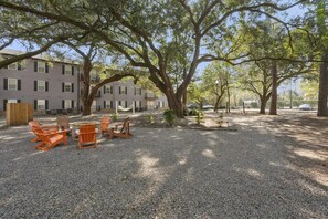 A gravel patio with outdoor seating and large trees. - Landing Chic 2bd, Gym (Wilmington)