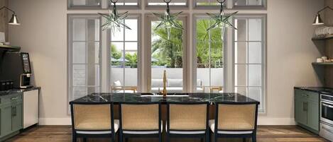 A kitchen with a marble island, wicker chairs, and a coffee machine.
