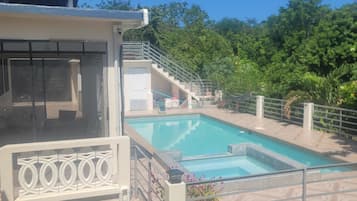 A swimming pool with a view of a building and trees in the background.