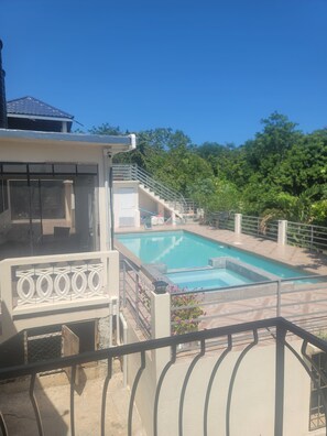 Una piscina con vista su un edificio e alberi sullo sfondo.