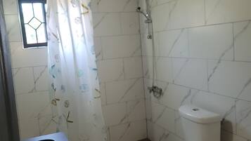 A bathroom with a shower, toilet, and sink.