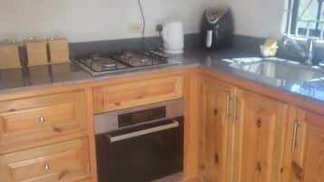 Una cucina con mobili in legno, un fornello a gas, un forno integrato e una finestra con vista.