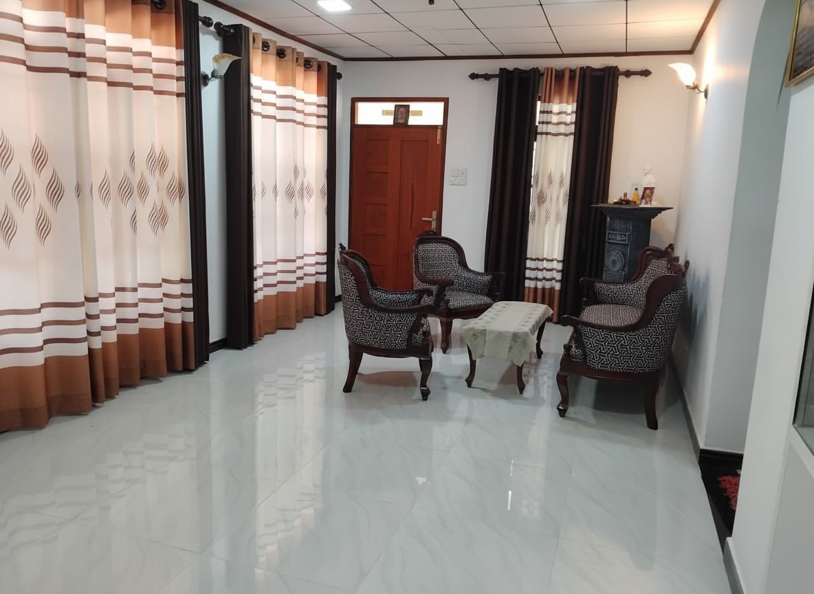 Una habitación con puerta de madera, cortinas estampadas y una mesa con sillas.