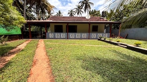 A house with a tiled roof, a covered porch, and a well-maintained lawn. - Chathu Villa Bentota (Bentota)