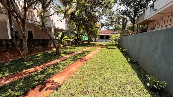 A pathway leading through a well-maintained garden area with a paved walkway and grass. - Chathu Villa Bentota (Bentota)