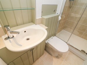 A bathroom with a sink, toilet, and shower. - Crag Cottage (Settle)