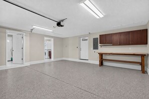 A spacious room with a kitchenette, a wooden bench, and a ceiling-mounted projector. - Spectacular renovated 3-bedroom house in Jax Beach with pool patio & yar (Jacksonville Beach)