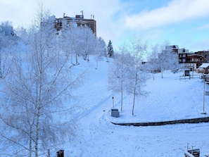 Schneebedeckte Landschaft mit Gebäuden und Bäumen.