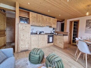 Eine moderne Küche mit Holzausstattung und einem Essbereich mit Tisch für zwei Personen.
